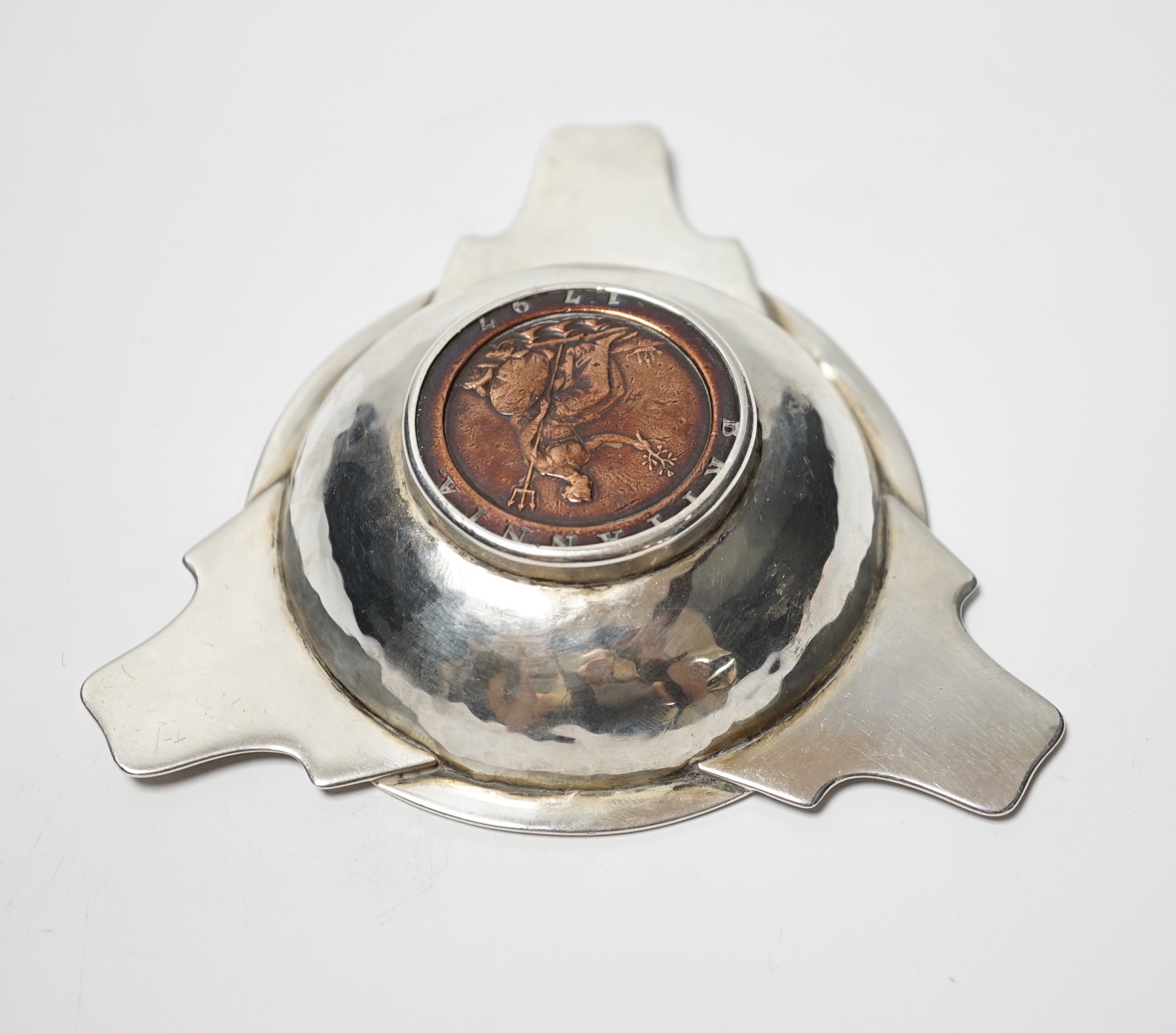 A George V Arts & Craft silver tri-form dish, by Albert Edwards Jones, Birmingham, 1913, the base with inset George III 1797 cartwheel penny, 10.8cm.